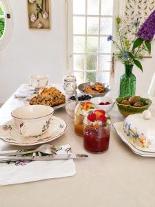 a table topped with plates and bowls of food at Les oiseaux de passage - chambre d hôtes, paisible in Gaillon +13 photos