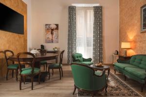 a living room with a green couch and a table and chairs at Hotel Roma in Bologna