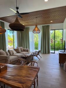a living room with couches and tables and windows at Julim Flora - Eco Villa in Amed