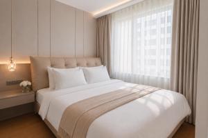 a bedroom with a large white bed with a window at 1BR Solice Apartment Capri in Ban Thalat Choeng Thale