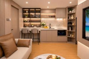 a living room with a couch and a kitchen at 1BR Solice Apartment Capri in Ban Thalat Choeng Thale +13 photos
