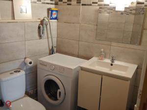 a small bathroom with a washing machine and a sink at Studio centre ville d'orange in Orange