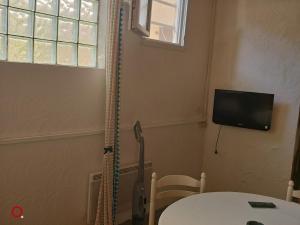 a room with a table and a television on the wall at Studio centre ville d'orange in Orange