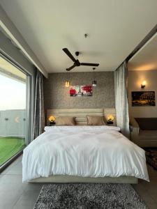 a bedroom with a large bed with a ceiling fan at Luxurystay-supernova in New Delhi