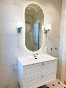 a bathroom with a white sink and a mirror at Nyoppusset leilighet i klassisk hus! in Lillehammer +10 photos