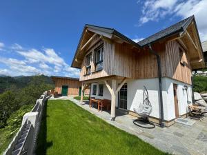 a house on a hill with a green yard at Alpenchalet Sonnberg in Kalwang