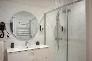 a bathroom with a shower and a sink and a mirror at Apartamento Menacho in Badajoz