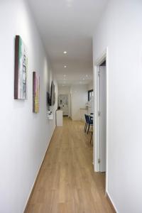 a hallway with white walls and a wooden floor at Apartamento Menacho in Badajoz