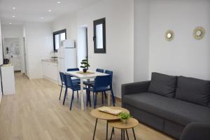 a living room with a couch and a table and chairs at Apartamento Menacho in Badajoz +22 photos