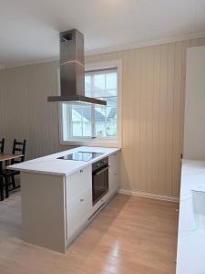 a kitchen with white cabinets and a stove top oven at Nyoppusset leilighet i klassisk hus! in Lillehammer