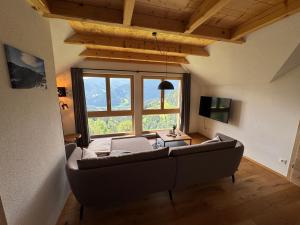 a living room with a couch and a large window at Alpenchalet Sonnberg in Kalwang