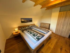 a bedroom with a bed in a room with wooden floors at Alpenchalet Sonnberg in Kalwang