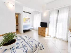 a white room with a bed and a television in it at Residence Glicini in Finale Ligure