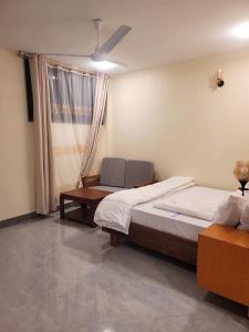 a bedroom with two beds and a chair and a window at Moveck Inn in Dar es Salaam