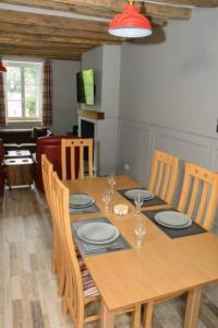 a wooden table with chairs and a dining room at The Old Post Office Gite -Jouac in Jouac