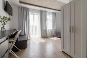 a white apartment with a desk and a room with windows at BLOMMA Niechorze in Niechorze