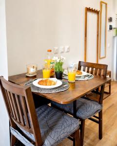 a wooden table with two plates of food and orange juice at Le Cocon Signature in Château-Thierry +7 photos