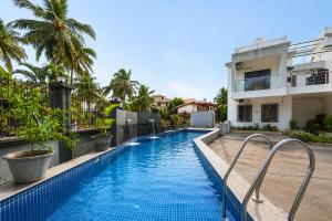 a swimming pool in front of a building at Go Offline Homes - Designer 2BHK with Pool Near Candolim in Parra