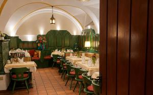 a dining room with white tables and green chairs at DORMERO MaHo Steyr in Steyr
