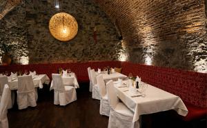 a restaurant with white tables and a brick wall at DORMERO MaHo Steyr in Steyr +11 photos