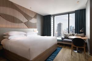 a bedroom with a bed and a desk and a couch at Courtyard by Marriott Phnom Penh in Phnom Penh +53 photos