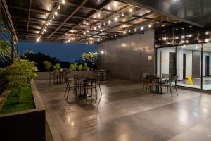 an outdoor patio with tables and chairs and lights at Kalya Hotel Bandung Dago in Bandung