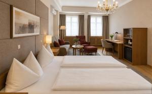 a hotel room with two beds and a living room at DORMERO MaHo Steyr in Steyr