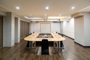 a conference room with a large table and a whiteboard at Kalya Hotel Bandung Dago in Bandung
