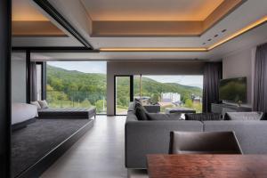 a living room with couches and a large window at Sansui Niseko in Kutchan