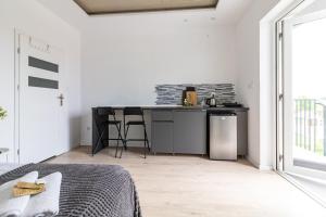 a bedroom with a kitchen with a counter and a bed at BLOMMA Niechorze in Niechorze