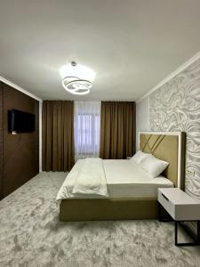 a bedroom with a large bed and a television at Karibi in Kyzylorda