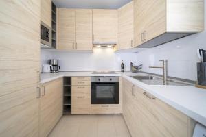 a kitchen with wooden cabinets and a sink at Villa Turquesa in Playa Blanca