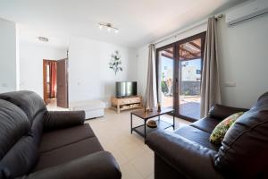 a living room with a couch and a television at Villa Turquesa in Playa Blanca