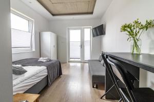 a bedroom with a bed and a desk with a chair at BLOMMA Niechorze in Niechorze