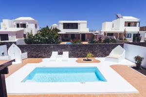 a villa with a swimming pool in front of a building at Villa Turquesa in Playa Blanca