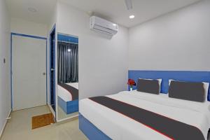 a bedroom with a large bed with a blue headboard at Collection O Leo Palace in Surat