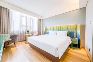 a bedroom with a large white bed and a desk at Manxin Hotel Suzhou Jinfeng Road in Suzhou +52 photos