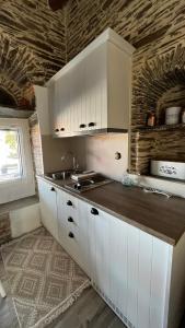 a kitchen with white cabinets and a sink at The Kamaraki Project in Kórthion +26 photos
