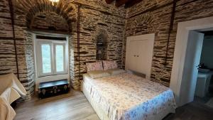 a bedroom with a bed in a brick wall at The Kamaraki Project in Kórthion