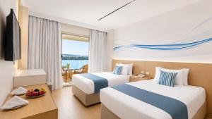 a hotel room with two beds and a balcony at Obelisk Nile Towers in Aswan +48 photos