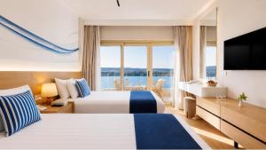 a hotel room with two beds and a large window at Obelisk Nile Towers in Aswan