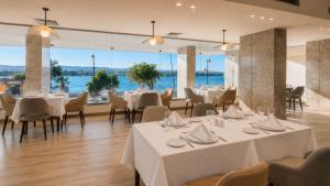 a restaurant with white tables and chairs and a large window at Obelisk Nile Towers in Aswan