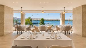 a dining room with tables and chairs and a view of the water at Obelisk Nile Towers in Aswan