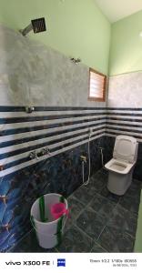 a bathroom with a toilet and a sink and a tub at VvM COTTAGE in Thiruchendur
