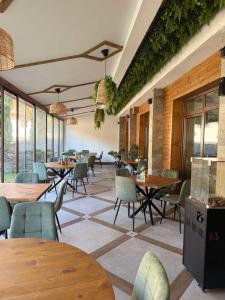 a restaurant with tables and chairs and windows at Family Hotel BOHEMA in Ognyanovo