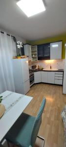 a kitchen with a table and a blue chair at Apartment Grapevine in Kornić