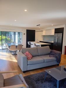a living room with a couch and a kitchen at Mangawhai Palms in Mangawhai