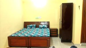 a bedroom with a bed with a blue comforter at The Stay Spot in Kharar