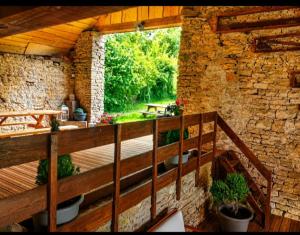an outdoor deck with potted plants and a stone wall at Cabane Des Boiseries in Esnans