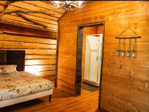 a bedroom with a bed in a log cabin at Cabane Des Boiseries in Esnans